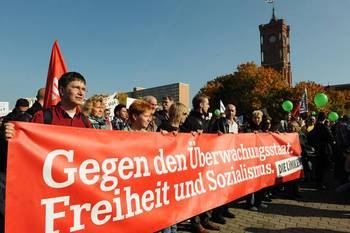 Mitglieder der Partei DIE LINKE tragen ein Transparent auf dem steht „Gegen den Überwachungsstaat. Freiheit und Sozialismus.“